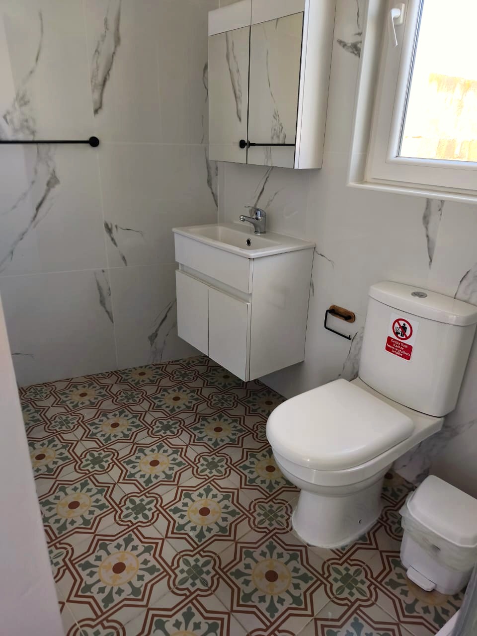 Modern bathroom with marble walls and traditional Maltese patterned tiles