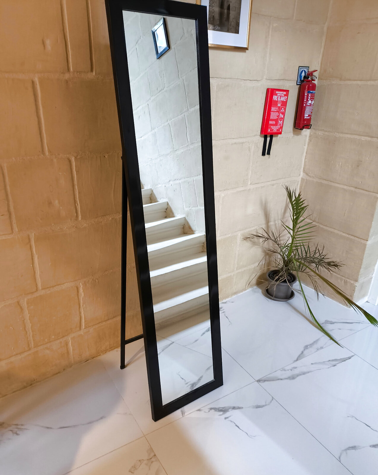 Entrance hall with full-length mirror, staircase and limestone walls
